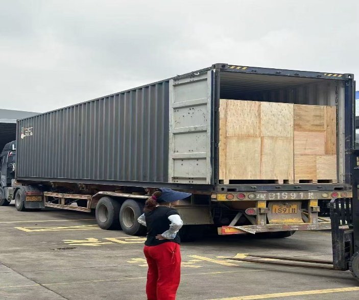 Wooden crates with slush machines being loaded into a shipping container for Singapore